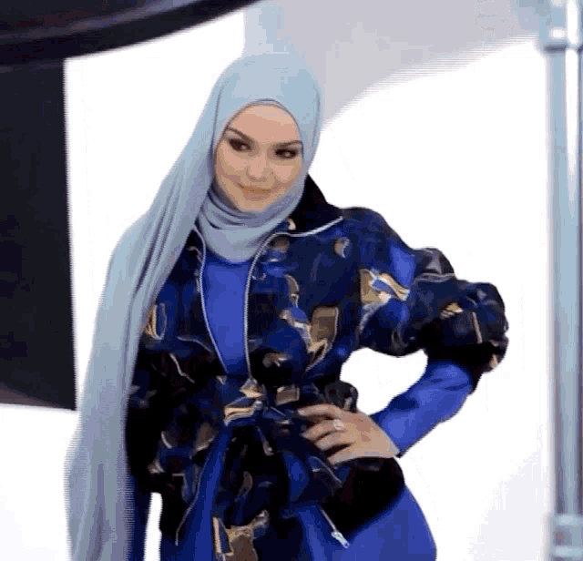 a woman wearing a blue hijab and a blue jacket