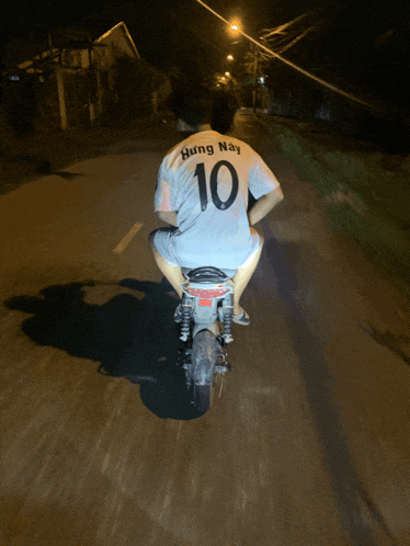 a person on a motorcycle wearing a shirt that says hung nay