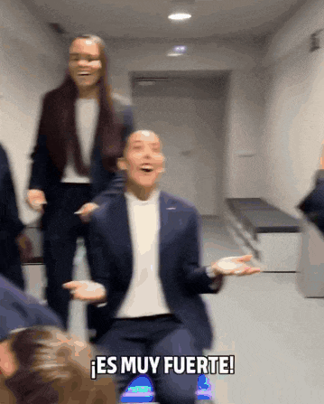 a man in a suit is kneeling down in a hallway and says es muy fuerte