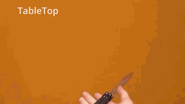 a close up of a person 's hand with the word tabletop written above it