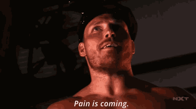 a man without a shirt says pain is coming in a dark room