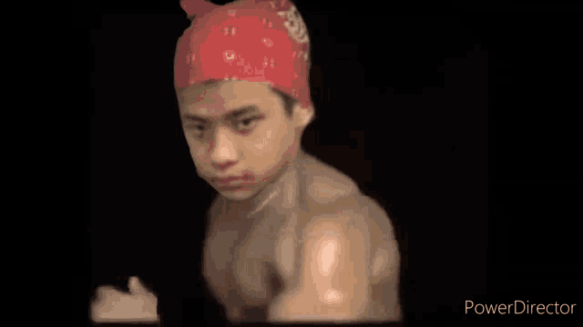 a young man wearing a red bandana is standing in the dark .