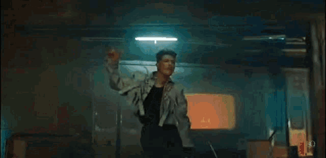 a young man is dancing in a dark room in front of a train .