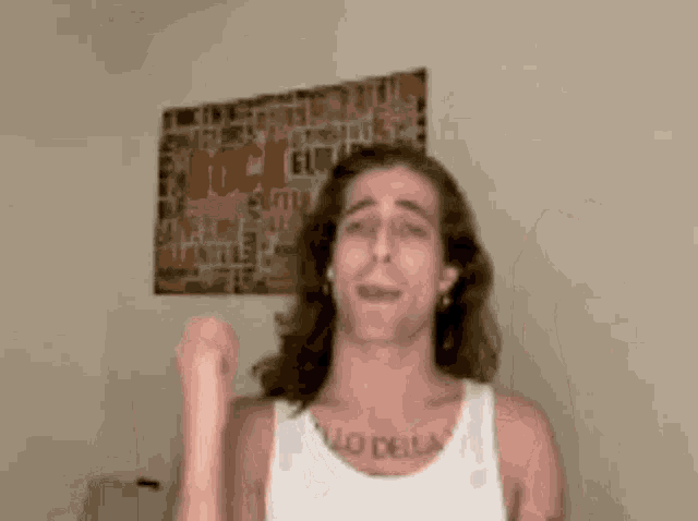 a man wearing a white tank top has a tattoo on his chest that says " lo della "