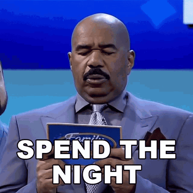 a bald man in a suit and tie is holding a flyer that says spend the night