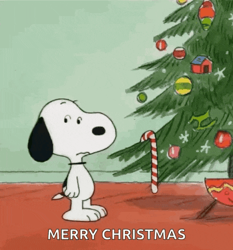 snoopy is standing in front of a christmas tree with a candy cane and wishing merry christmas .