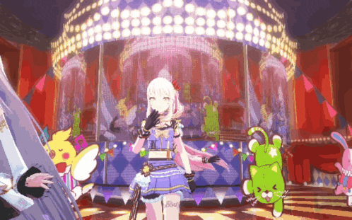 a girl in a blue dress is standing on a stage with a green stuffed animal