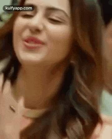 a close up of a woman 's face with her eyes closed and her tongue out .