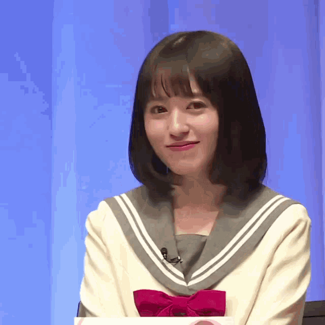 a girl in a school uniform with a red bow on her neck