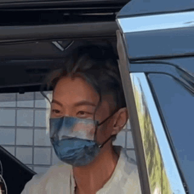 a man wearing a face mask is sitting in the back seat of a car