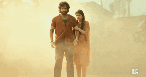 a man and a woman are standing next to each other with hk written on the bottom of the image