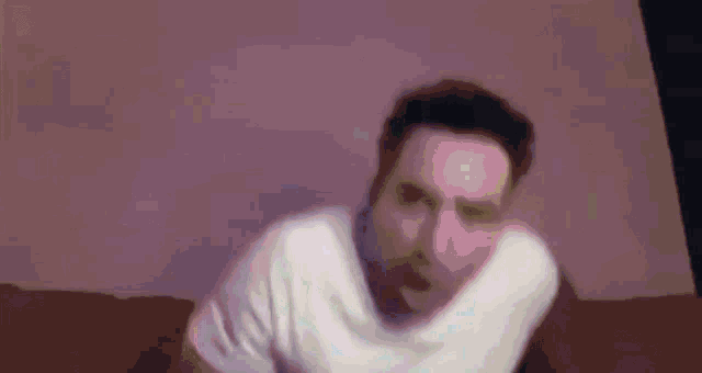 a man in a white shirt is making a face