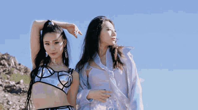 two women standing next to each other with one wearing a blue bra