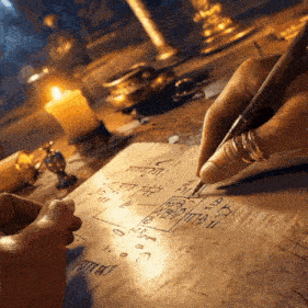 a person is writing on a piece of paper with a pen and a candle in the background ..