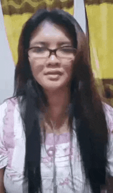 a woman wearing glasses and headphones is making a face .