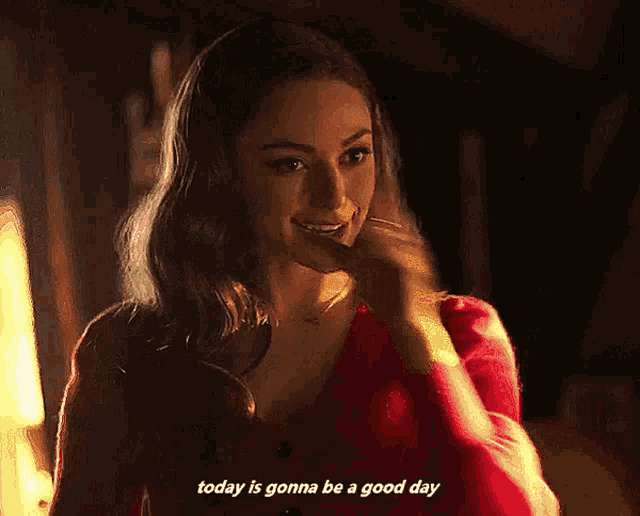 a woman in a red top is smiling and says today is gonna be a good day