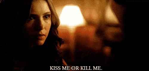 a woman is looking at a man with the words `` kiss me or kill me '' written below her .