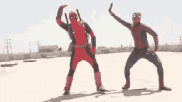 deadpool and spider-man are standing next to each other in a desert .