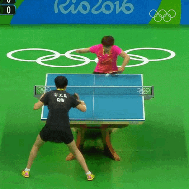 a woman playing ping pong with a shirt that says u.x.x. china
