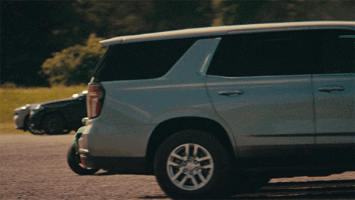 a gray suv is parked in a gravel lot