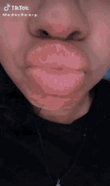 a close up of a woman 's face with her eyes closed and a pink lip .
