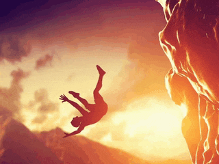 a person is falling from a cliff at sunset