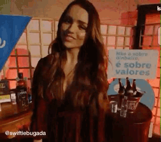 a woman is standing in front of a table with a sign that says " é sobre valores "