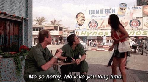 a man sitting at a table talking to another man with the words me so horny me love you long time written below him