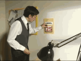 a man is looking at a calendar that says abril