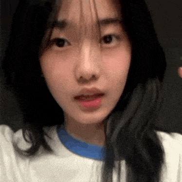 a close up of a young woman 's face with long black hair .
