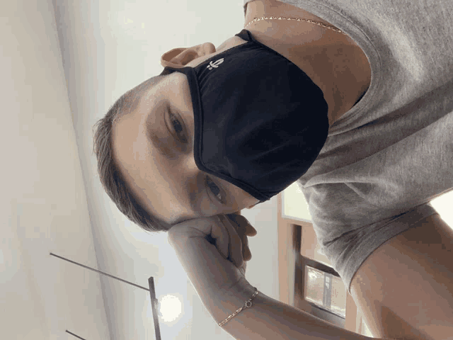 a man wearing a black face mask with the letter s on it