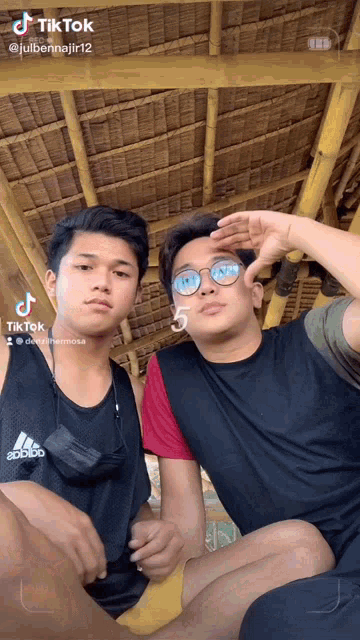 two young men are posing for a picture with a tiktok watermark on the bottom right
