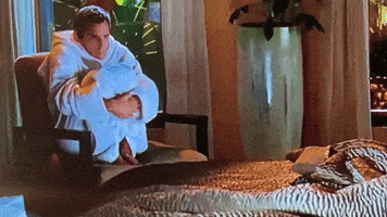 a man in a bathrobe is sitting in a chair holding a baby