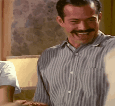 a man with a mustache in a striped shirt is smiling