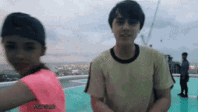 a boy and a girl standing next to each other on a rooftop
