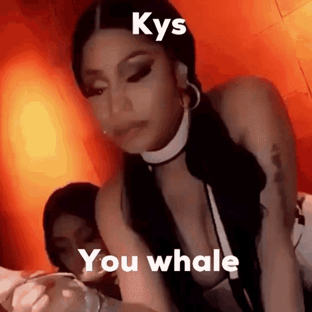 a woman is sitting on a bed with the words `` kys you whale '' written on the screen .