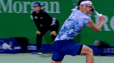 a man is playing tennis in front of a morgan sign