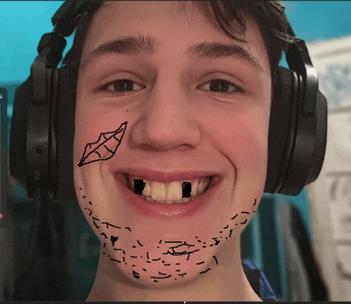 a young man wearing headphones has a drawing of a mouth and teeth on his face