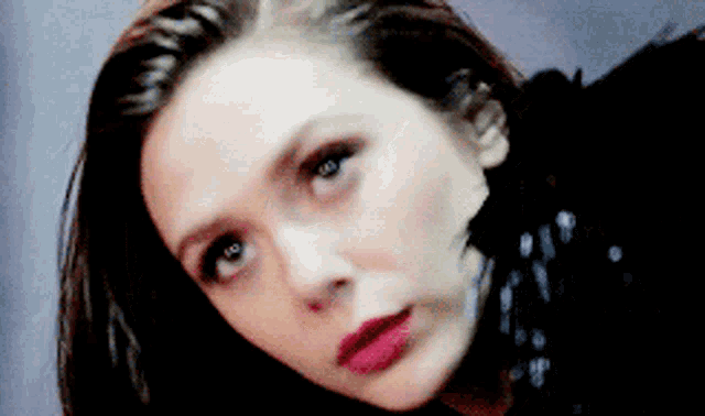 a close up of a woman 's face with red lipstick on her lips