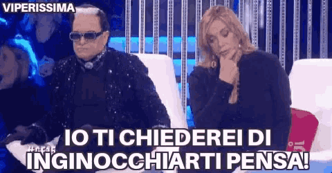 a man and a woman are sitting in chairs and the man is wearing sunglasses