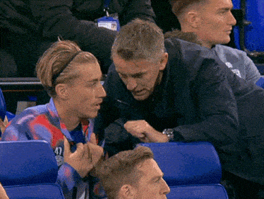 a man wearing a headband with the number 47 on it is talking to another man