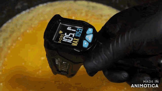 a person holding a digital thermometer that reads 105 degrees celsius