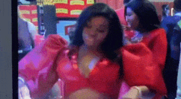 a woman in a red dress is dancing in front of a crowd of people .