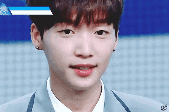 a close up of a young man 's face with a blue and white stripe on his forehead
