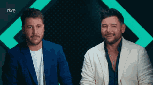two men are sitting next to each other with rtve written on the bottom right