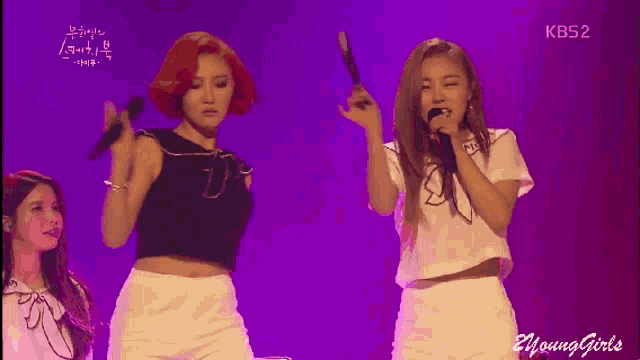 a group of young girls are performing on a stage