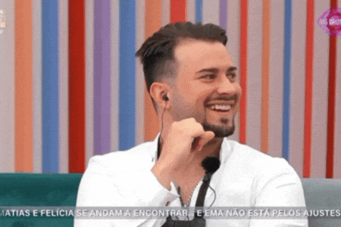 a man with a beard is smiling while wearing earbuds