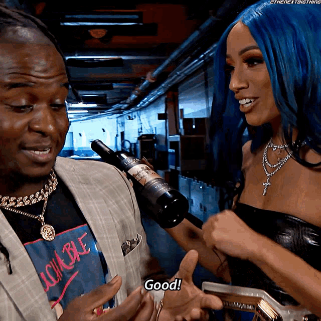 a woman with blue hair is holding a bottle of wine while talking to a man in a suit
