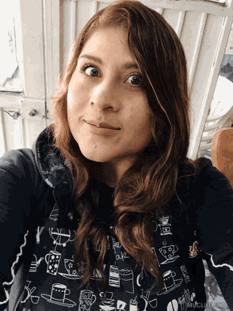 a woman taking a selfie with muglife.com written on the bottom