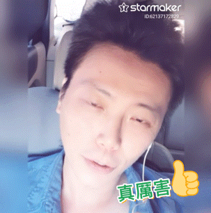 a man in a blue shirt is giving a thumbs up with a starmaker logo behind him